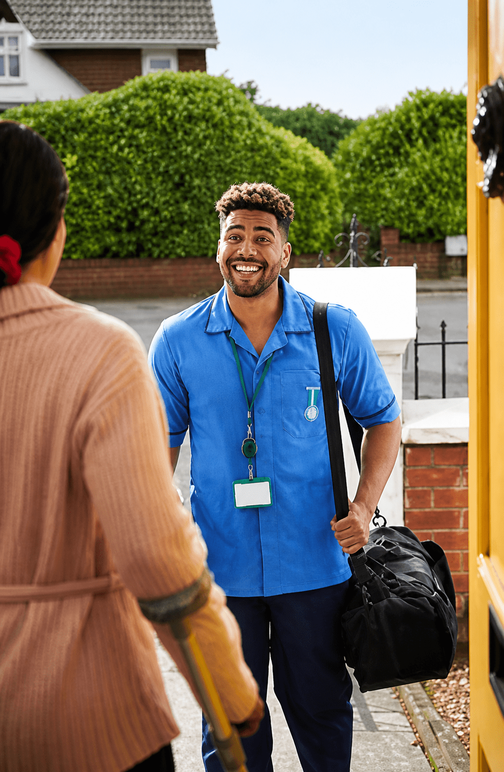 Smiling man in blue uniform visiting home.
