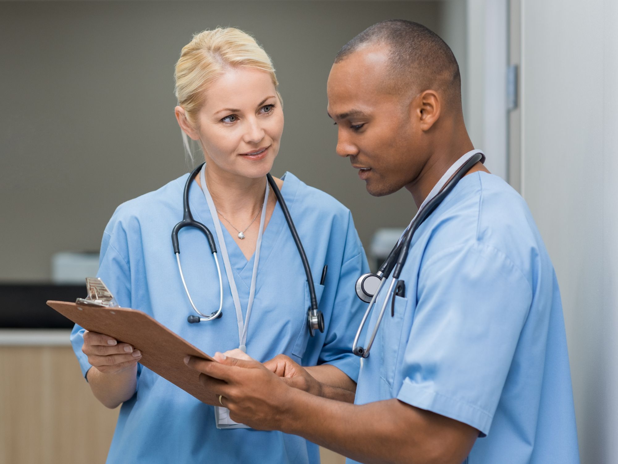 Two healthcare professionals discussing patient chart.